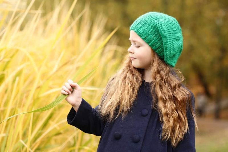 O fată irlandeză drăguță într-o pălărie verde care se distrează în parc