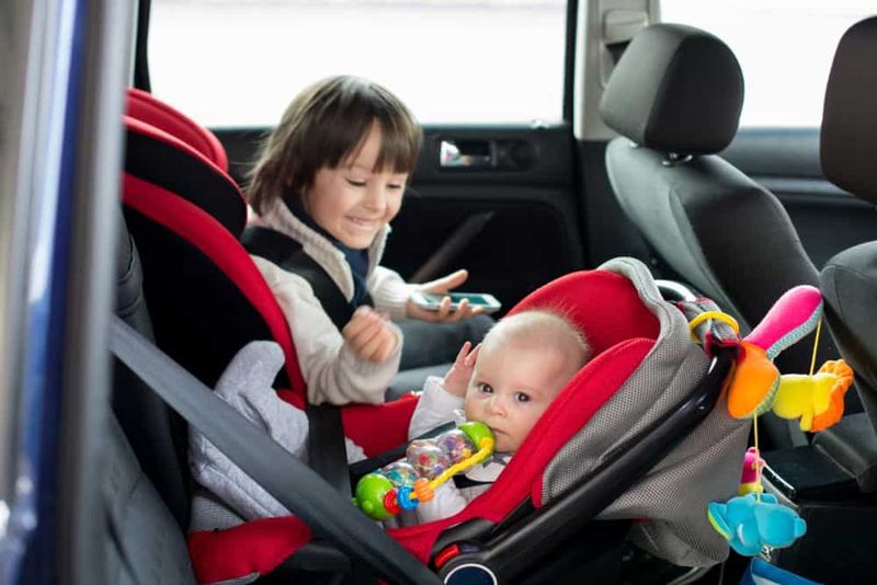 Kleinkind und Baby in Autositzen